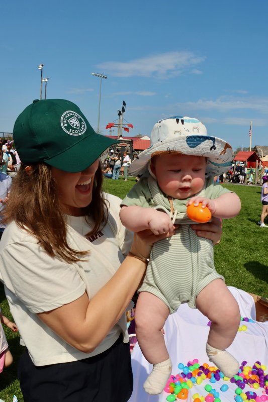 Grace Ruoff, left, holds 8-month old Nolan Siney, who holds an Easter egg.