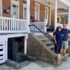 Sarah Prieto, left, and her husband Stephen Matthews in front of their home at 405 Savannah Road in Lewes. The couple is asking the city to allow them to have a dog-grooming business in the basement of their home. Neighbors in the row houses on either side are opposing the business. BILL SHULL PHOTO
