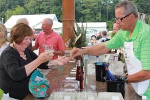 Marvin Carney of Rehoboth Beach serves Helene Nicoletti of Pot Nets as part of the event's wine tasting. BY MELISSA STEELE