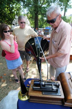 Mak and John Peterson of Lewes are given a demonstration of an antique phonograph by Charles White of Country Treasures Antiques.