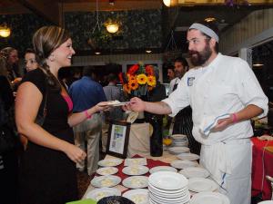 Event hostess Alice Bavis from WBOC gets a sample of the black truffle macaroni and gourmet cheese from chef Craig Clifton of Porcini House. BY STEVEN BILLUPS