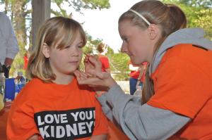 Emily Johnson of Laurel gets her face painted by volunteer Lizzie Leonard of Dover. BY RON MACARTHUR