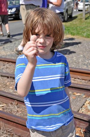 James Steiner, 5, of Lewes, holds up a smashed penny he put on the tracks. Many onlookers followed suit and put coins on the track to keep as keepsakes. BY NICK ROTH