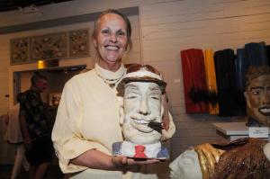 Proudly holding a ceramic Jurors Excellence Award sculpture titled “About Face #3” is Kate Lear. Another face is on the backside of the cigar smoking face. BY STEVEN BILLUPS