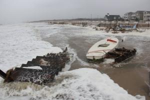The winds shifted around to the north northwest at the time of high tide Monday morning helping to hold down the first high tide, bad enough as it is anyway. The winds blew lots of debris up on the public beach at Lewes including a set of dune stairs and a wayward Sunfish sailboat. BY DENNIS FORNEY