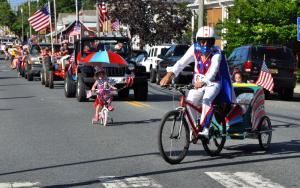 Evel Knievel, aka Derek Cole, leads Kemper and Willet Cole as they ride their bicycles along the parade route. BY RON MACARTHUR