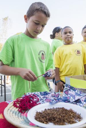 Levin Harmon creates a prayer tie, made of tobacco, fabric and a red string. Tobacco represents a prayer and red is a sacred color. These were carried by the walkers as a blessing. BY DENY HOWETH