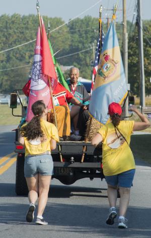Two runners follow the lead truck carrying Chief William Daisey who believes running is part of the Indian way, brings one close to the Mother Earth and is the way ancestors traveled. BY DENY HOWETH