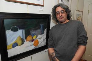 Standing with one of his still lifes titled “Bounty of Fruit,” is Jason Janjanin of Rehoboth Beach. Janjanin also works with landscapes, which are also displayed in the show. BY STEVEN BILLUPS