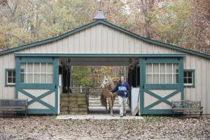 Dr. Christina Dayton Wall checks up on a horse's gait as she leads her out of the barn gates. BY DENY HOWETH