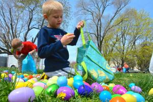 Jacob Medding, visiting from New Mexico, can't fill his Easter basket fast enough as he grabs eggs during the Midway Assembly of God's egg hunt. BY RON MACARTHUR