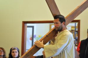 Donnie Bunting carries a cross into the church during a play about the Easter story. BY RON MACARTHUR