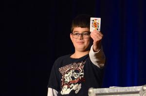 Out of view of the magician, John Sommerfield of Lewes shows the audience the card he has selected out of the deck. Marko the Magician was able to pick the card out of a top hat using a small lasso. BY RON MACARTHUR