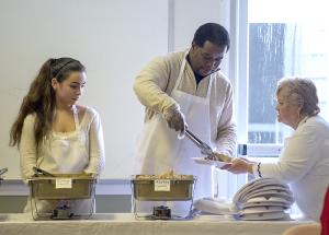 Alicia Hernandez, left, and Phil Winder fill plates with turkey for volunteer Audrey Markel. BY DENY HOWETH