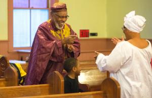 The Rev. Harvey Sparkman of St. James Union Church, and his wife Kai Sparkman, perform a dance down the aisle of a wedded couple in traditional African fashions. BY DENY HOWETH