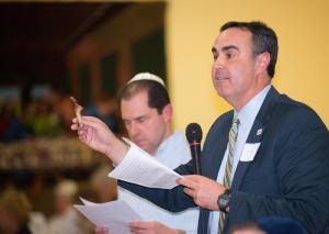 Sen. Ernie Lopez, R-Lewes, holds the lamb bone from the Seder plate and reads from the scripture. BY DENY HOWETH