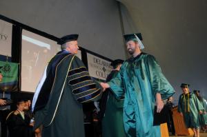 Shaking hands with Del Tech President Mark Brainard is Jason Kreer from Lewes. Greer received hid associates degree in Radiologic Technology. BY STEVEN BILLUPS