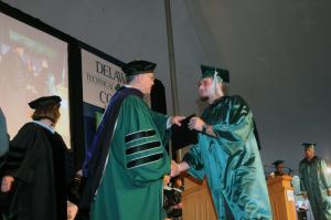 Robert Foxx from Lewes receives an associates degree in Criminal Justice. Presenting the diploma is Scott A. Green, chairman of the board of trustees BY STEVEN BILLUPS