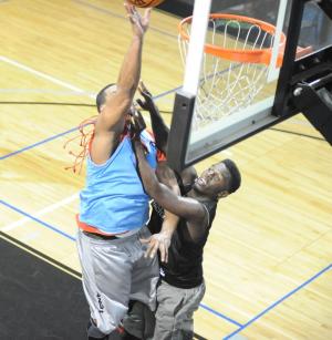 Brian Polk, a former Temple player, takes it to the basket guarded by Solomon Cox. BY DAVE FREDERICK