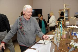 Nancy Hecker, an Epworth member from Lewes, admires the jewelry in the art room. BY STEVEN BILLUPS