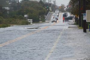 At high tide Saturday, traffic is directed off flooded Savannah Road after it crosses the Lewes-Rehoboth Canal bridge. BY RON MACARTHUR