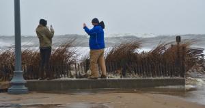 A couple share a memory by taking photographs with their phones as they brave the wind and rain on the Rehoboth Beach Boardwalk. BY RON MACARTHUR