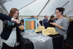 Under the "Not Wine" sign, Amanda Holcom from the Crooked Hammock pours a summer lager for Kim Hutchins of Lewes. BY STEVEN BILLUPS