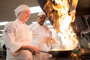 Felicia Blevins, left, oversees a flaming pan as Chuck Groce II looks on. SUBMITTED PHOTO