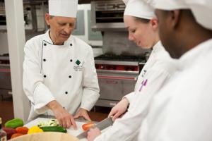 Delaware Tech Instructional Director Ed Hennessy oversees vegetable prep work by Rhiannon Fitz Gerald-Lorah. Darryl Davis is shown with back to camera. SUBMITTED PHOTO