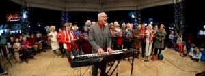 Rehoboth Beach and Main Street officials – left – join on the Bandstand to usher in the holiday season as Doug Yetter plays the keyboard. RON MACARTHUR PHOTO