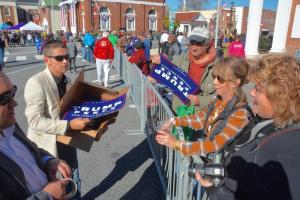 President-Elect Donald Trump committee members hand out signs along the parade route. RON MACARTHUR PHOTO