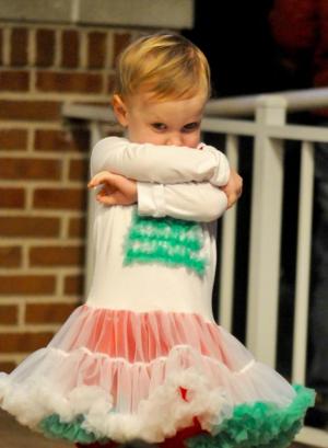 Caroline Rausch, who will be 2 years old on Christmas Eve, wraps herself up as she dances under the Rehoboth Bandstand. RON MACARTHUR PHOTO