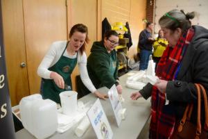 Gretchen Lauer, left, and Samantha Martinez offer samples of Woodside Farm Creamery ice cream, the judges’ Fire and Ice pick.