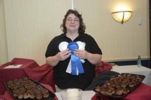 Kim Kneipp, manager of The Pointe, holds a first- and two third-place ribbons. The Chocolate Tiramiso Cream Puffs took home first in the Other category and third place in the Cookie and Pie categories. Chocolate Festival