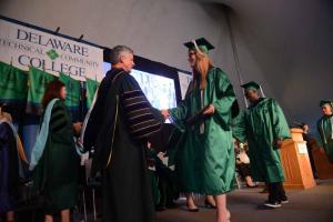 Shannon Maner from Milton graduated with honors in Electronics Engineering Technology. Maner is shown receiving a congratulatory handshake from Del Tech President Dr. Mark Brainard. Del Tech 2107