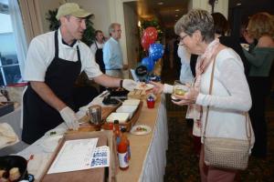 Serving Bacon Wrapped Crab Imperial to Carol Wetherhold is Fins Hospitality Group Disitrict Manager Scott Garner. Top Chef