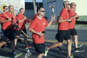 Cpl. Andrew Shea, Delaware State Police Troop 5, brother of Chris Shea, the honored officer, carriers the flame out of town on Rehoboth Avenue Extended.