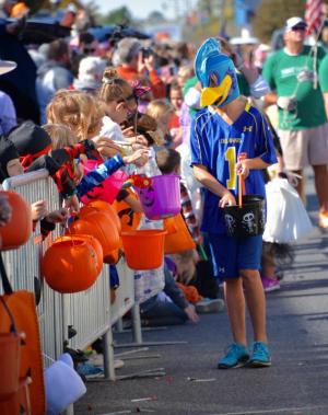 Anxious children put out their pumpkins and bags to collect treats along the parade route. RON MACARTHUR PHOTO