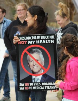 Erin Greenberg holds a sign protesting the vaccine mandate.