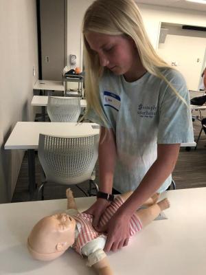 Ellen Ramsey provides compressions during a practice round of infant CPR.