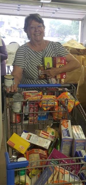 Cape Henlopen Food Basket volunteer Paula Conti helps unload and stock groceries collected through the Stamp Out Hunger Food Drive.