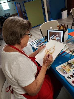 Linda Towers paints seashells among the other Cape Artists members.