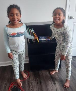 Excited to check out their new bookcase and books are 6-year-old twins Ethan, left, and Eian Bush. The Bushes became the 150th Habitat for Humanity family given a home library by Reading Opens Doors. The program is currently seeking a new director. SUBMITTED PHOTO
