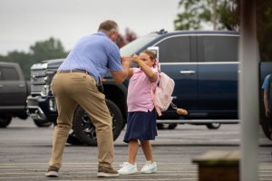 DCS Milton campus Principal Drew Jensen, left, executes a perfect back-to school greeting with Maddie Hines.