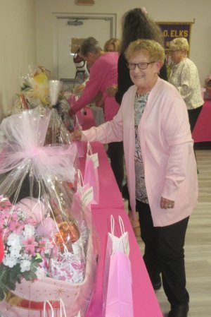 Elks member Bernice Holmbraker drops a ticket in one of the baskets for the silent auction, hoping to be a big winner.