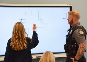 Fred Thomas eighth-grader Brynn Evick takes a guess at determining what happened based on the accident diagram created by SRO Cpl. Nick Yatsko.