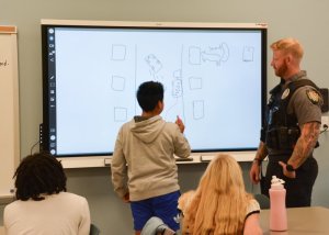 Showing his classmates and SRO Cpl. Nick Yatsko what he thinks happened in accident scenario two is Fred Thomas eighth-grader Santos Ramos-Ramirez.