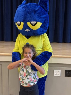 Avery Scott makes a hand heart to show her love for Pete the Cat.