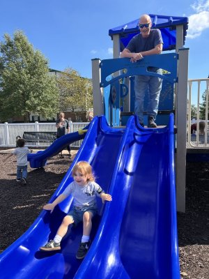 Young Morgan Drake glides down the slide under the watchful eye of his grandfather Morgan Drake.