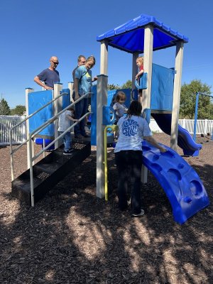 Gathered on the play structure are adults (l-r) Morgan Drake, Clinton Hart, Natalya Segura and Elisabeth Armstrong; and youngsters Connor Fickett, Morgan Drake and Bella Hart.